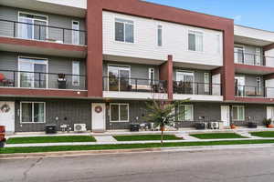 View of front of house with a balcony and brick siding
