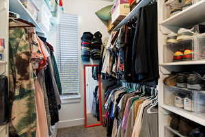 Walk in closet with built in shelves and window.