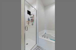Bathroom featuring a bath and a shower stall