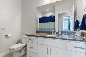 Full bathroom featuring a shower with shower, vanity, granite countertops, and light tile patterned floors