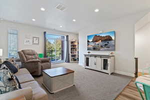 Living room featuring stairway, can lighting, access to balcony, and an open floorplan
