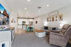 Living area featuring can lighting, light carpet, and an open floorplan