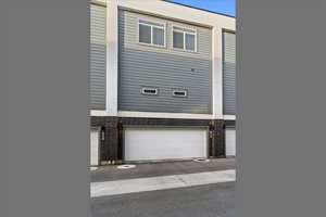 Rear view of property featuring brick siding and garage