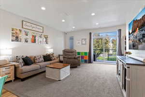 Living room featuring stairway, can lighting, access to balcony, and an open floorplan