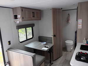 Kitchen with light wood-type flooring, light countertops, and brown cabinets
