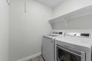 Laundry area featuring separate washer and dryer and light wood-style floors