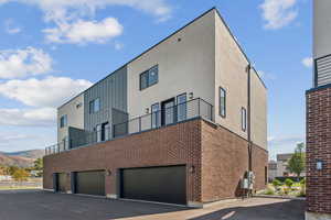 Back of house featuring a patio area, stucco siding, and brick siding