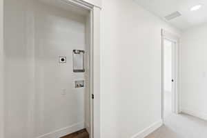 Hallway with dark carpet and recessed lighting