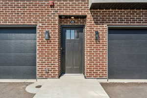 View of exterior entry featuring brick siding