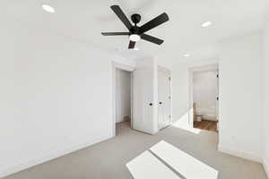 Unfurnished bedroom featuring light colored carpet, a closet, recessed lighting, a ceiling fan, and ensuite bathroom