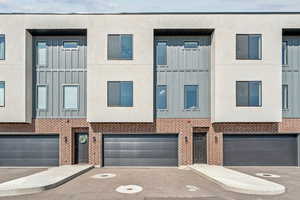 View of front of house featuring board and batten siding, brick siding, and driveway