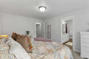 Bedroom featuring light carpet and connected bathroom