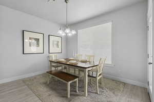 Dining room with light wood finished floors and a chandelier