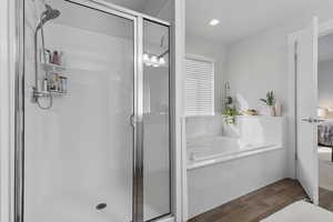Bathroom featuring wood tiled floors, a garden tub, a stall shower, connected bathroom, and recessed lighting