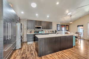 Beautiful open and modern kitchen featuring stainless steel appliances, a large quarts center island, and chic cabinets