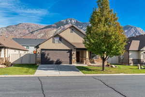Craftsman house with board and batten siding, mountain view, front porch, driveway, and garage