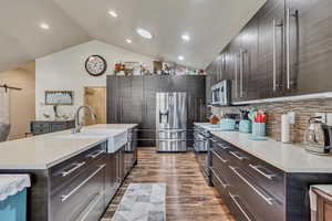 Beautiful open and modern kitchen featuring stainless steel appliances, a large quarts center island, and chic cabinets