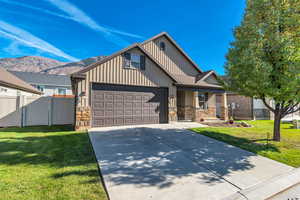 Craftsman house with board and batten siding, mountain view, front porch, driveway, and garage