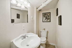 Half bath featuring a sink and crown molding