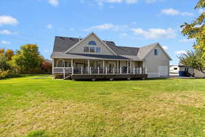 Rear view of house with a garage, a yard, and roof with shingles
