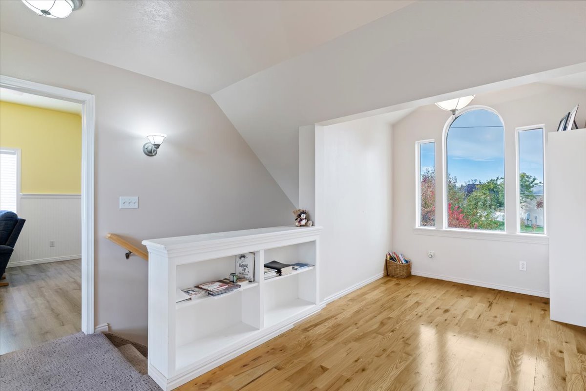 Bonus room featuring light wood-style floors and lofted ceiling