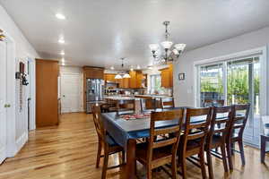 Dining room with light wood-style flooring, recessed lighting, and a chandelier