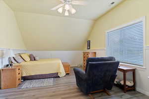 Bedroom with lofted ceiling, wood finished floors, and a ceiling fan