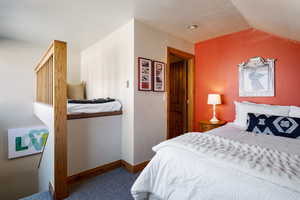 Bedroom with carpet and lofted ceiling