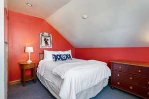 Carpeted bedroom with lofted ceiling