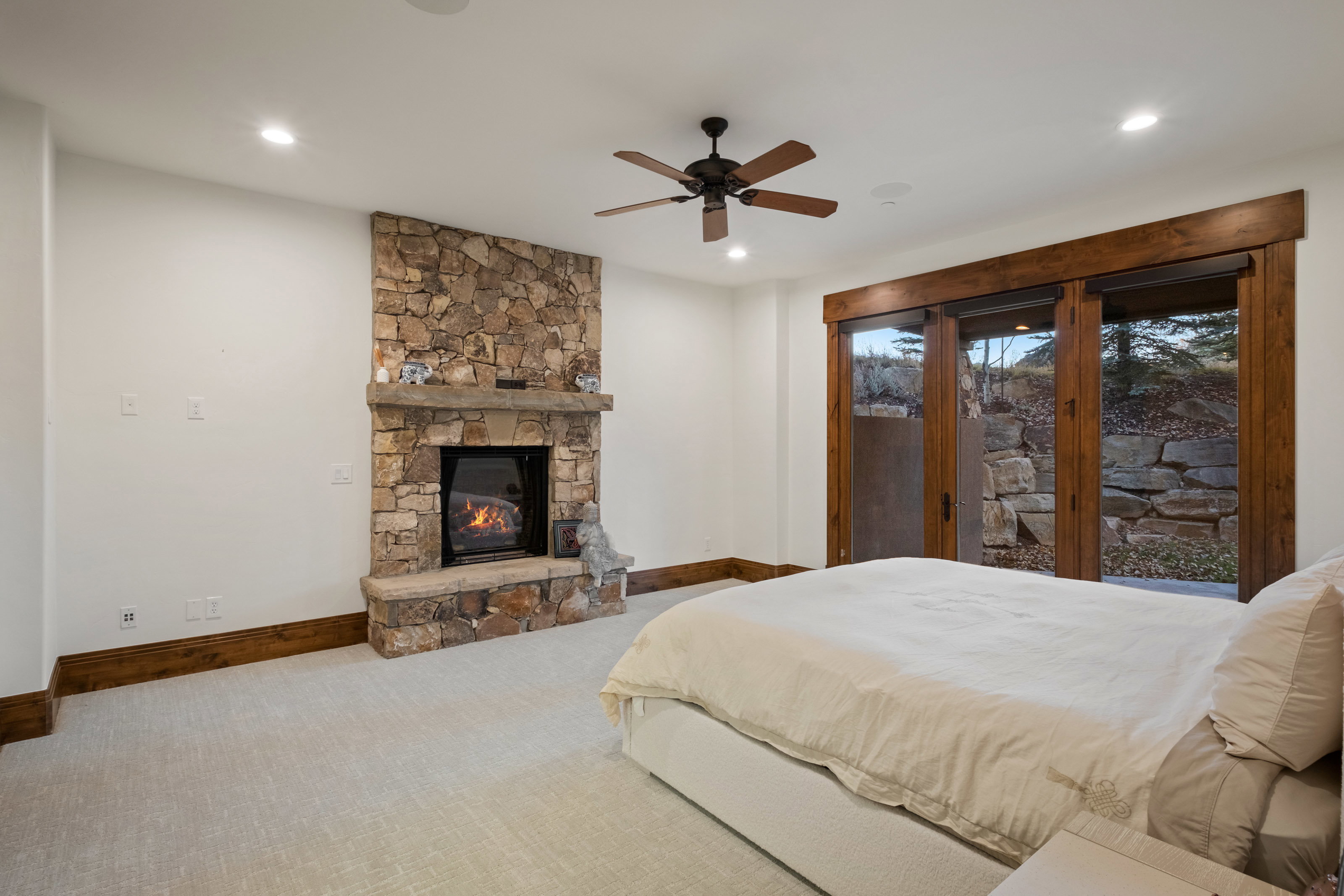 Bedroom with access to exterior, carpet, a fireplace, and a ceiling fan