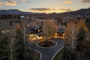 View of front of property featuring a mountain view and curved driveway