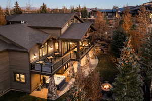 Rear view of house with a patio area and a shingled roof