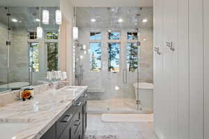 Bathroom with a shower stall, double vanity, a freestanding bath, and light tile patterned floors