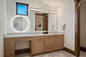 Bathroom featuring double vanity and baseboards
