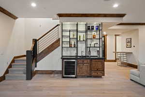 Indoor wet bar featuring open shelves, light wood-style flooring, stairway, beam ceiling, and wine cooler