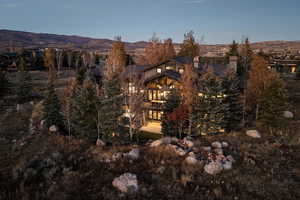 Rear view of house featuring a balcony, a mountain view, and a chimney