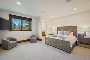 Bedroom with light carpet, ensuite bathroom, and recessed lighting