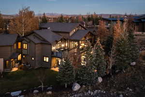 View of front facade with a front yard, a mountain view, and a shingled roof