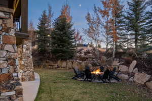 View of grassy yard with a patio and a fire pit
