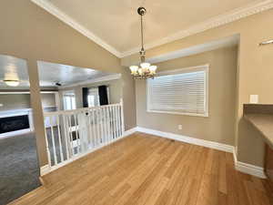 Dining area with chandelier, bamboo flooring, window with view to east mountain and back yard.
