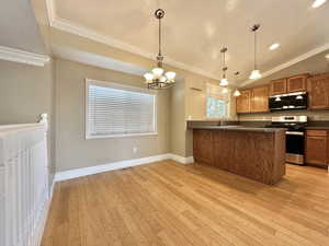 Kitchen with Corian counter tops, new stainless steel appliances, and lovely pendant lighting