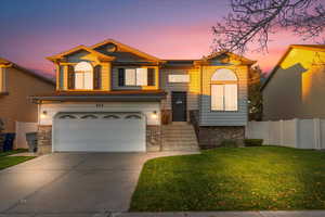 View of front of property featuring concrete driveway, brick siding, and a garage