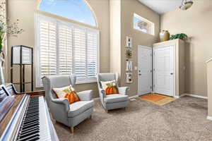 Sitting room with a high ceiling and carpet floors