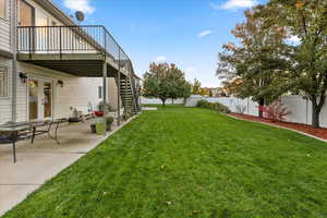 Fenced backyard featuring a patio area, stairs, and a wooden deck