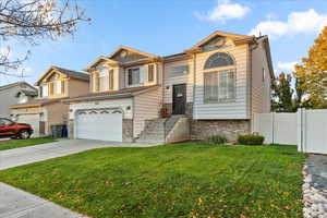 View of front of home with driveway, an attached garage, and brick siding