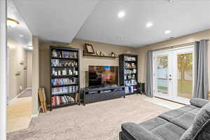 Living room with light carpet, light tile patterned floors, a textured ceiling, french doors, and recessed lighting