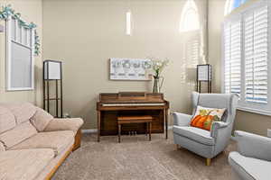 Sitting room with carpet flooring and a high ceiling