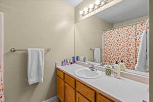 Bathroom featuring curtained shower and vanity
