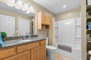 Full bath with light tile patterned flooring, vanity, and shower / bathtub combination with curtain