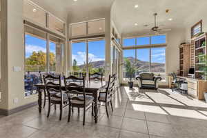 Tiled dining room featuring an office area, recessed lighting, a ceiling fan, and a towering ceiling